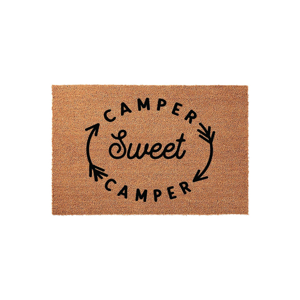 Camper Sweet Camper coir doormat featuring a natural brown fiber texture and black printed text with decorative arrows, creating a welcoming entrance accessory for your travel trailer, motorhome, or campsite outdoor living space.