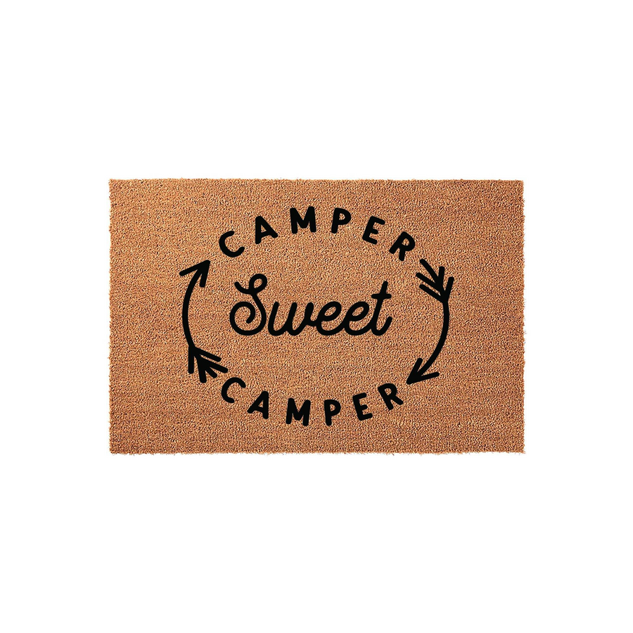 Camper Sweet Camper coir doormat featuring a natural brown fiber texture and black printed text with decorative arrows, creating a welcoming entrance accessory for your travel trailer, motorhome, or campsite outdoor living space.