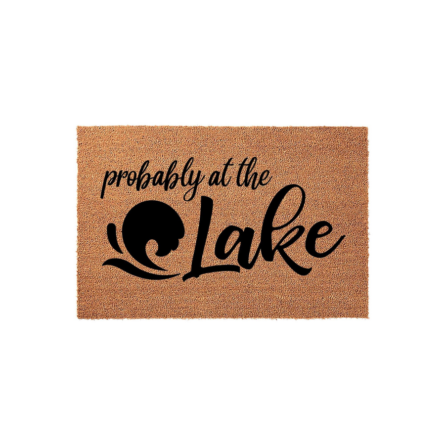 Probably at the Lake coir doormat featuring a natural tan fiber texture and bold black lettering, with a stylized wave icon integrated into the design for a fun outdoor cabin or lake house entryway decor aesthetic.