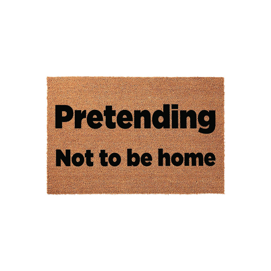 Funny Pretending Not to be Home doormat made of natural coir fiber with bold black text, centered on a plain white background for a clean look that adds a humorous touch to any front porch or entryway decor for your house.