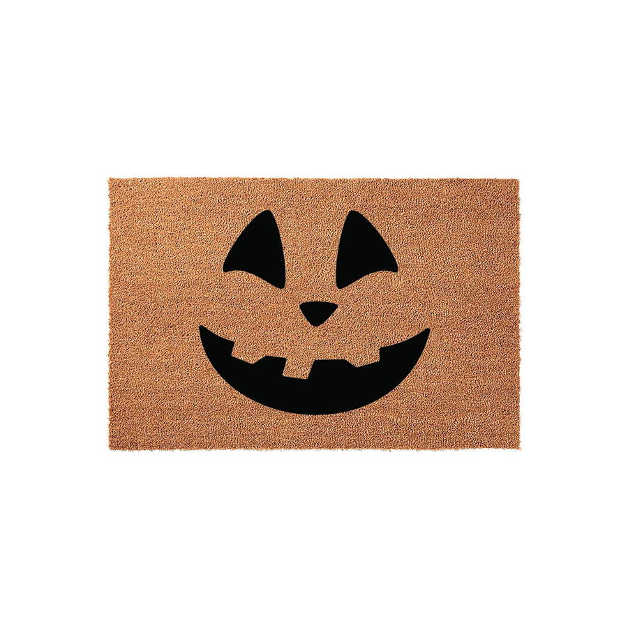 Jack-o-lantern Halloween doormat featuring a classic carved pumpkin face design printed in black on a natural coir fiber mat, creating a festive and spooky entryway decoration for the fall season on a clean white background.