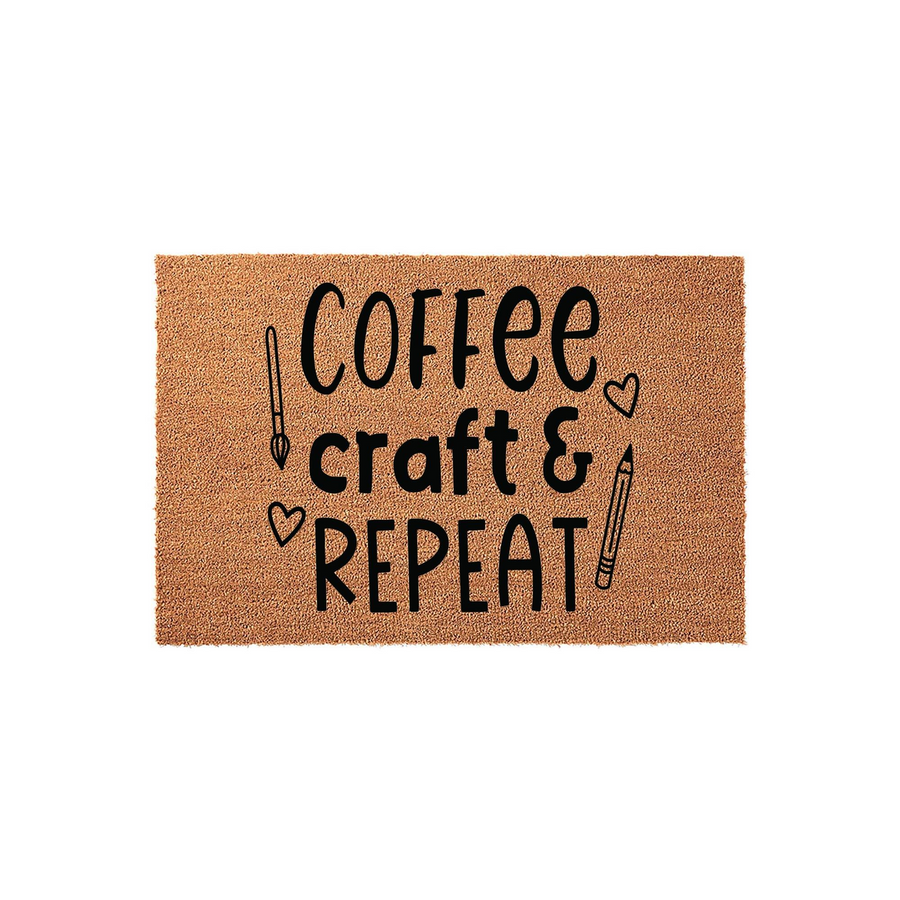 Coffee Craft and Repeat Coir Doormat featuring a natural tan fiber texture with black text and cute illustrations of a paintbrush, a pencil, and small hearts, making it a fun entryway decor piece for any creative person's home.