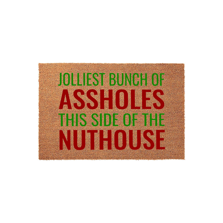Funny Christmas doormat featuring a natural coir texture with bold red and green text that reads Jolliest Bunch of Assholes This Side of the Nuthouse, making it a humorous holiday welcome mat for your front porch or entryway