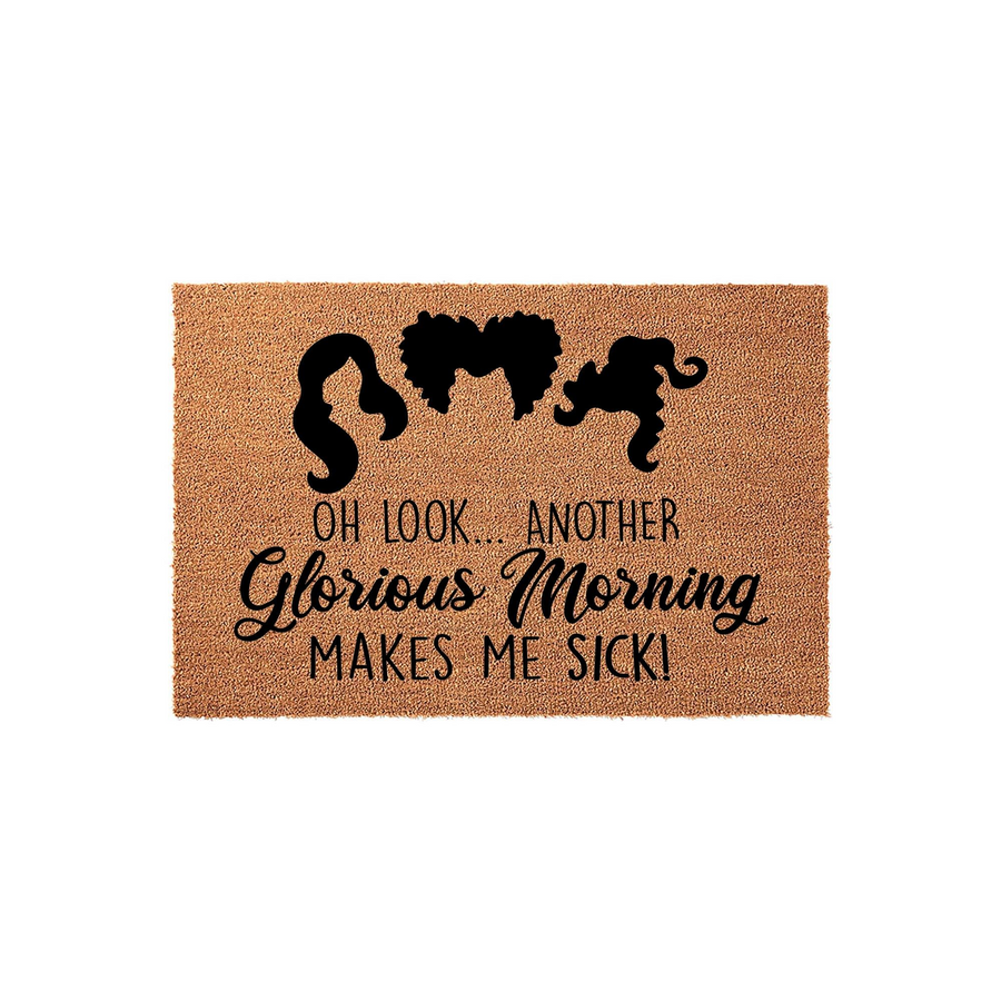 Hocus Pocus inspired coir doormat featuring the iconic silhouettes of the three Sanderson sisters above the text Oh Look Another Glorious Morning Makes Me Sick, perfect for a spooky Halloween front porch decor setup on a plain