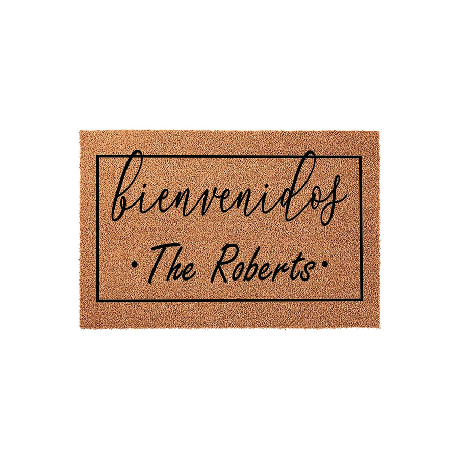 Personalized Bienvenidos doormat featuring a natural coir texture with a black rectangular border, elegant script lettering for the Spanish welcome, and space for a custom family name printed in a clean, modern font on a white