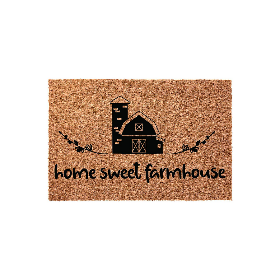 Home Sweet Farmhouse coir doormat featuring a black printed barn and silo illustration with decorative leafy branches, set against a natural brown coconut fiber background for a rustic country style entryway or front porch decor.