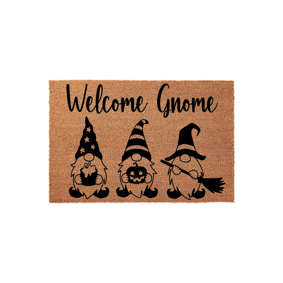 Halloween Welcome Gnome doormat featuring three cute gnomes in black ink on a natural coir background, with the text Welcome Gnome written in a script font above the gnomes holding a cauldron, a pumpkin, and a witch broom for