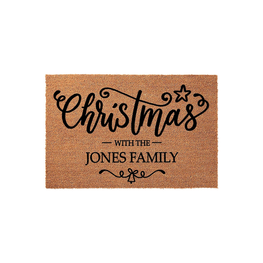 Personalized Christmas doormat featuring a natural coir texture with black script lettering that reads Christmas with the family name, accented by a star and a small bell icon for a festive holiday entryway decor piece.