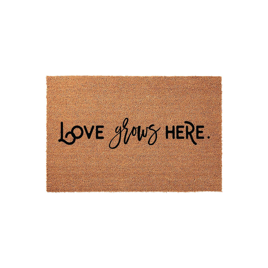 Love Grows Here coir doormat featuring a natural brown fiber texture and bold black script lettering, providing a welcoming and rustic touch to any front porch entryway or home decor setting for a family-focused household.