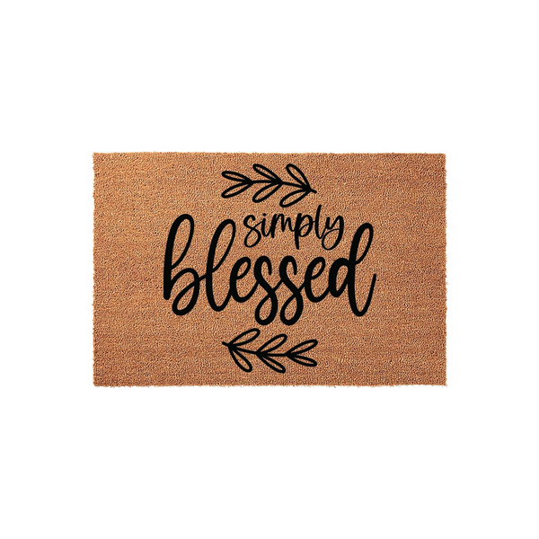 Simply Blessed coir doormat featuring a natural tan fiber texture and black script lettering, accented by simple hand-drawn leaf sprigs above and below the text to create a welcoming farmhouse style entrance for your front porch.