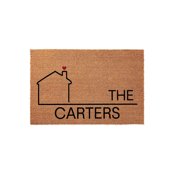 Personalized family name coir doormat featuring a minimalist black house outline with a small red heart on the chimney, displaying the text The Carters on a natural brown textured fiber background for a welcoming home entrance.
