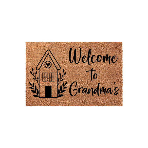 Grandma welcome doormat made of natural coir fiber, featuring a black printed graphic of a cozy house with a heart in the window and the text Welcome to Grandma's, set against a clean white background for a simple entryway decor