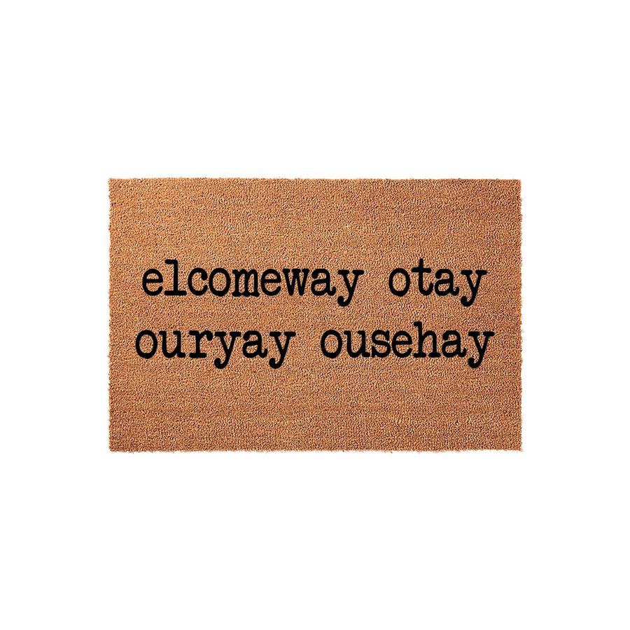 Pig Latin Welcome Doormat featuring a natural coir texture with the phrase elcomeway otay ouryay ousehay printed in bold black typewriter font, creating a fun and unique entryway accent for any home that appreciates a playful