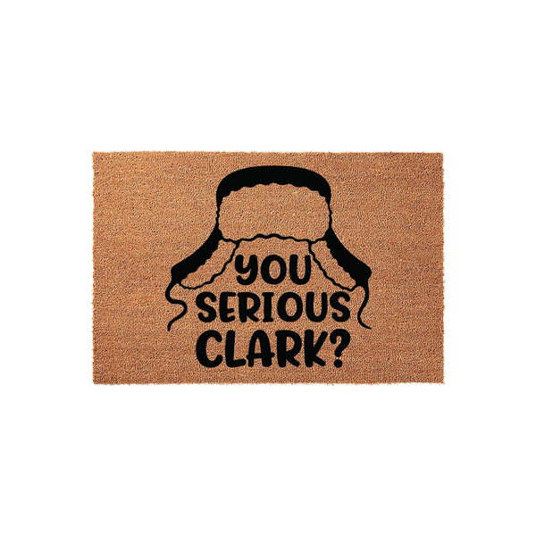 Funny Christmas movie quote doormat featuring a black graphic of a trapper hat and the text You Serious Clark? printed in bold letters on a natural tan coir fiber mat, perfect for a festive holiday entryway or front porch decor.