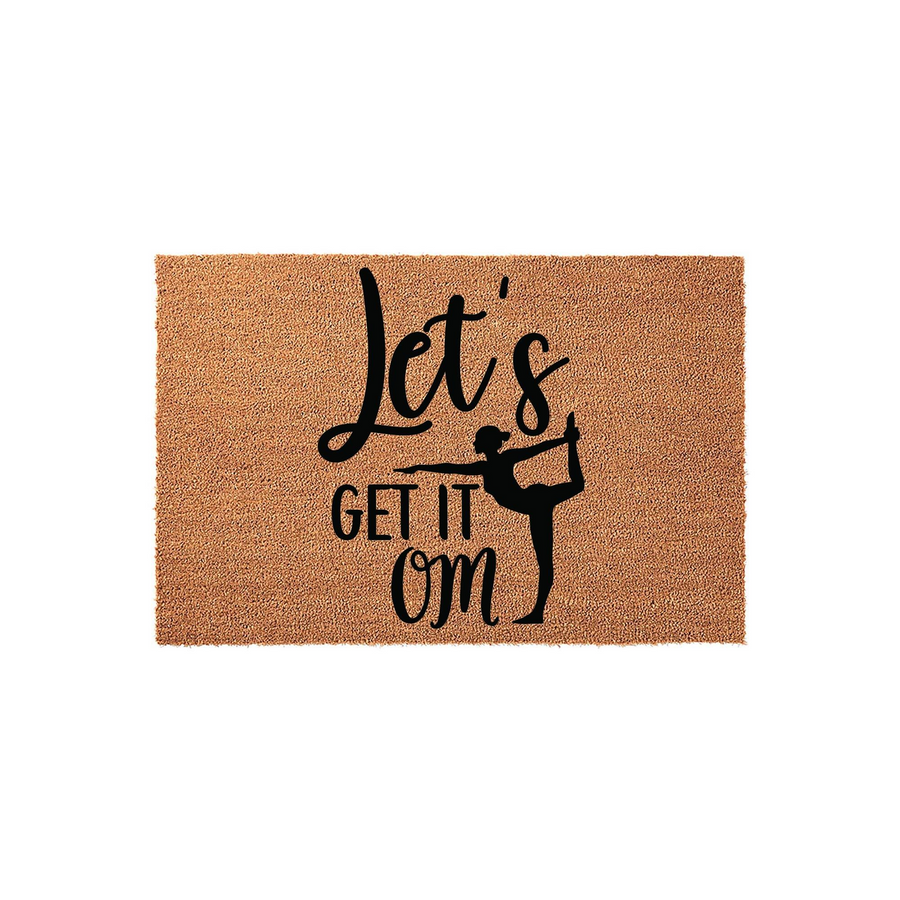 Yoga themed coir doormat featuring the punny phrase Let's Get It Om in black script lettering, accompanied by a silhouette of a person performing a dancer yoga pose on a natural brown textured fiber background for a home entryway.