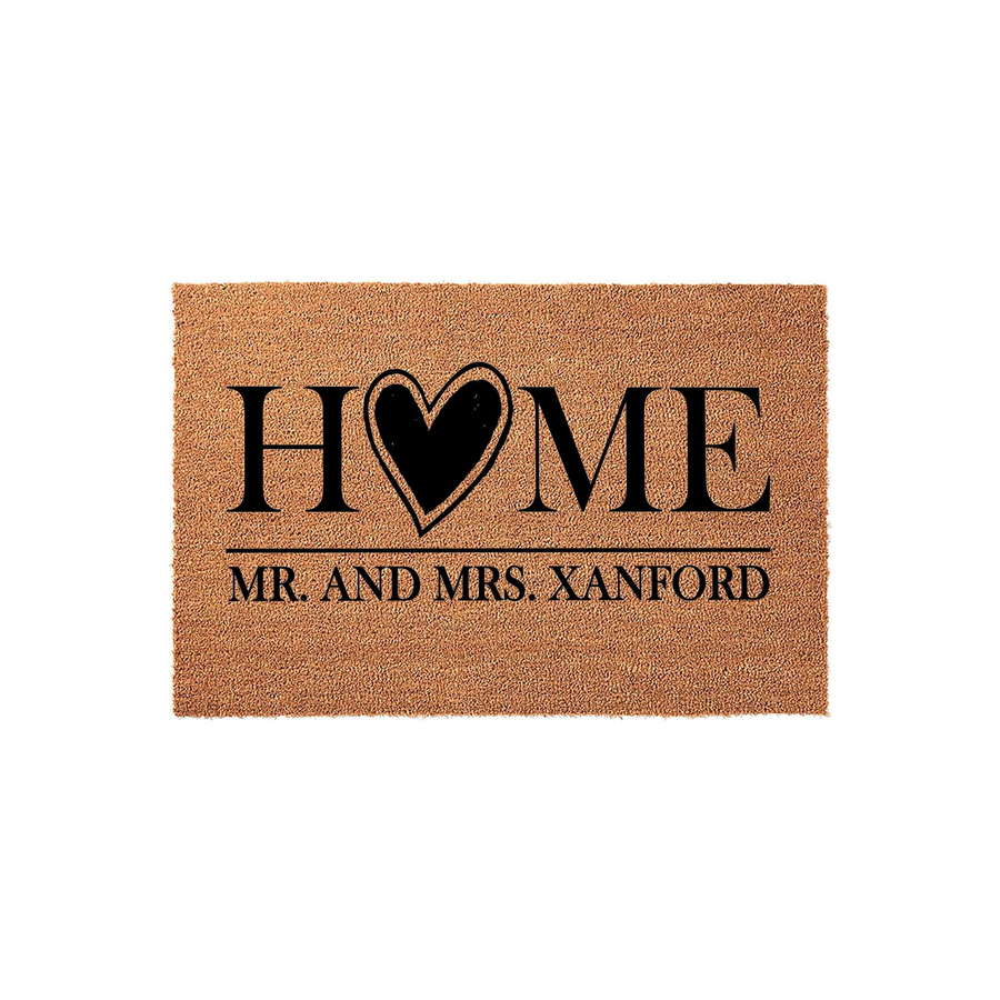 Personalized coir doormat featuring the word HOME with a heart replacing the letter O, customized with a family name below, set against a clean white background for a classic and welcoming entryway decor style for any new home.