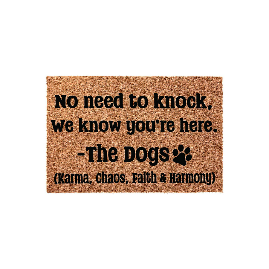 Funny Dog Themed Doormat featuring a natural coir texture and bold black text that reads No need to knock, we know you are here, signed by The Dogs with a paw print icon, making it a humorous welcome mat for any pet lover's front