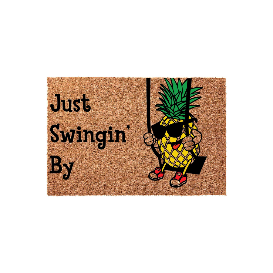 Just Swingin' By pineapple doormat featuring a fun cartoon pineapple wearing sunglasses and red sneakers while sitting on a swing, printed on a natural tan coir fiber mat against a clean white background for a tropical home