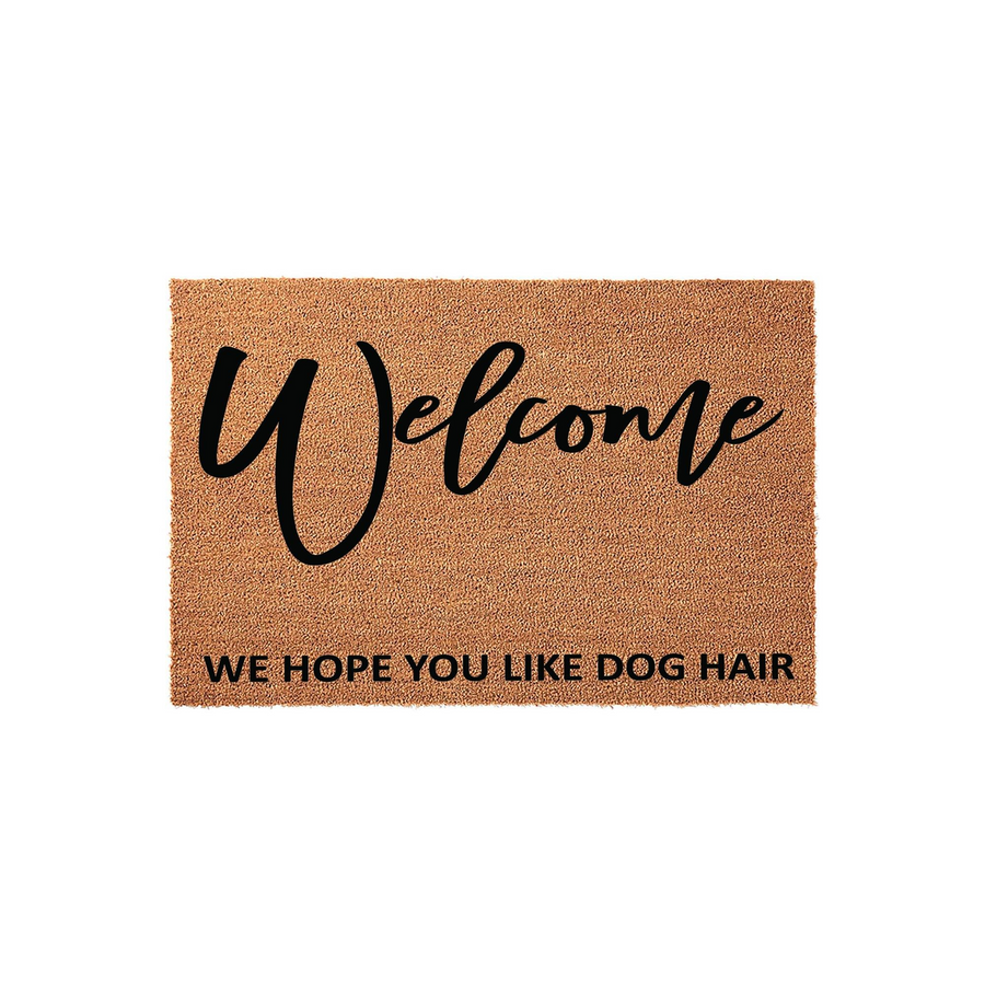 Funny Dog Hair Welcome Doormat featuring a natural coir texture with the word Welcome in a black script font and the humorous phrase We Hope You Like Dog Hair printed in a clean sans-serif font on a plain white studio background.