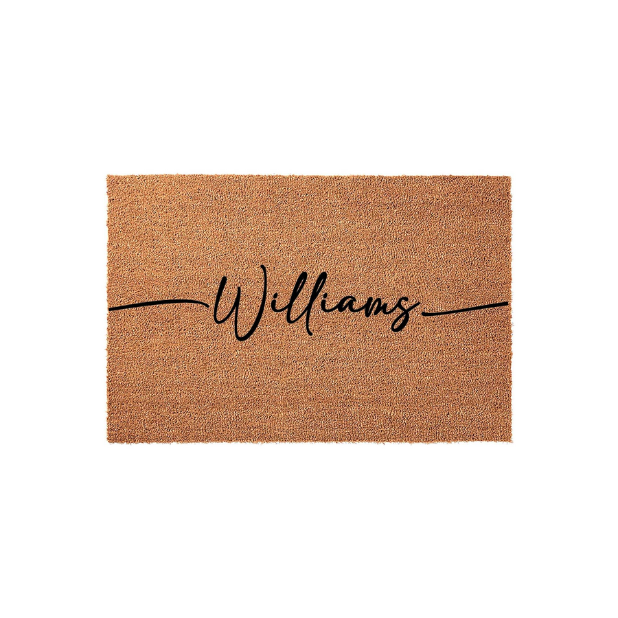 Personalized family name coir doormat featuring a natural tan fiber texture and elegant black script lettering centered across the middle, providing a durable and welcoming entrance decor piece for any front porch or home