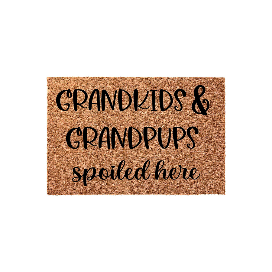 Grandkids and Grandpups Spoiled Here coir doormat featuring bold black lettering on a natural tan fiber background, creating a fun and welcoming entryway decor piece for a grandparent who loves their family and their pets.