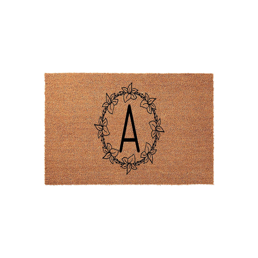Personalized monogram coir doormat featuring a large black letter A centered inside a delicate hand-drawn floral wreath, set against a natural tan textured coconut fiber background for a classic farmhouse entryway decor style.