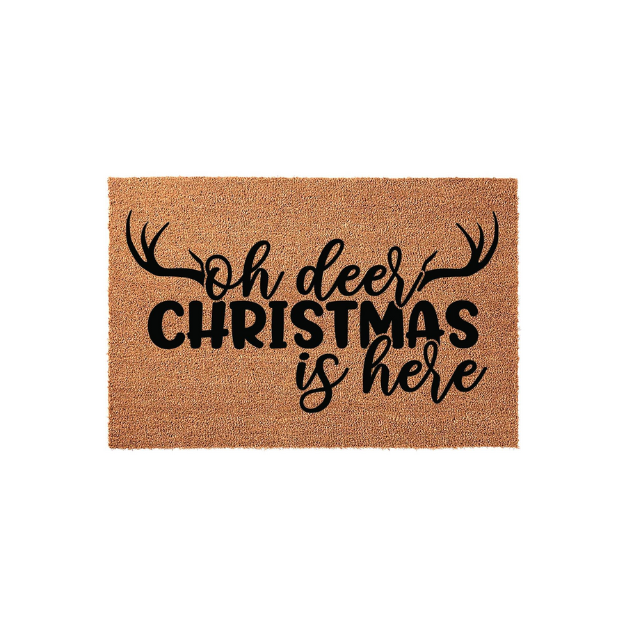 Oh Deer Christmas Is Here coir doormat featuring black text and stylized antler graphics on a natural brown fiber background, providing a festive and rustic holiday welcome for your front porch entrance during the winter season.