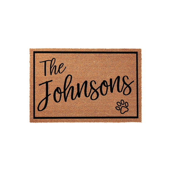 Personalized family name coir doormat featuring a black border, elegant script text for a custom last name, and a cute paw print accent, making it a charming and durable welcome mat for any pet-loving household entrance.