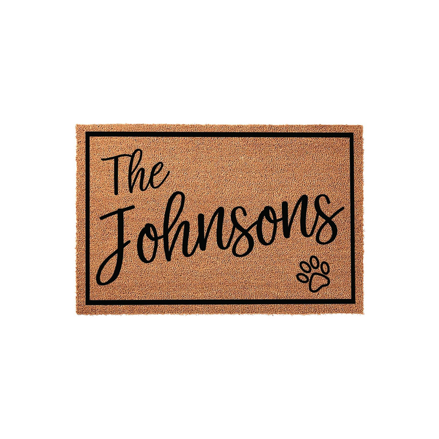 Personalized family name coir doormat featuring a black border, elegant script text for a custom last name, and a cute paw print accent, making it a charming and durable welcome mat for any pet-loving household entrance.