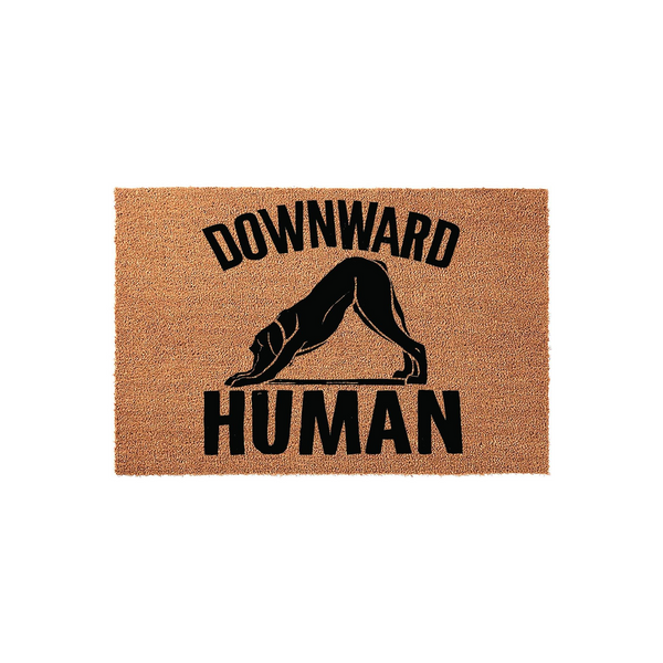 Downward Human yoga dog doormat featuring a natural coir texture with a black silhouette of a dog in a downward dog pose, humorously captioned with bold text on a plain white background for a fun entryway decor piece for pet