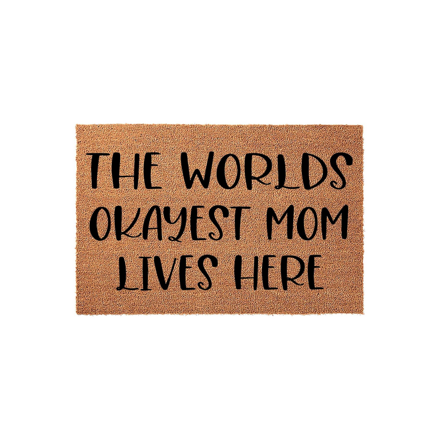 Worlds Okayest Mom Coir Doormat featuring a natural brown fiber texture and bold black lettering that reads The Worlds Okayest Mom Lives Here, making it a funny and welcoming front porch decor piece for any home entrance.