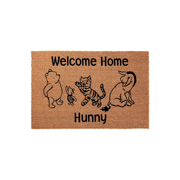Winnie the Pooh Welcome Home Hunny coir doormat featuring a black line art illustration of Pooh, Piglet, Tigger, and Eeyore on a natural brown fiber background, creating a charming entryway rug for any fan of the classic