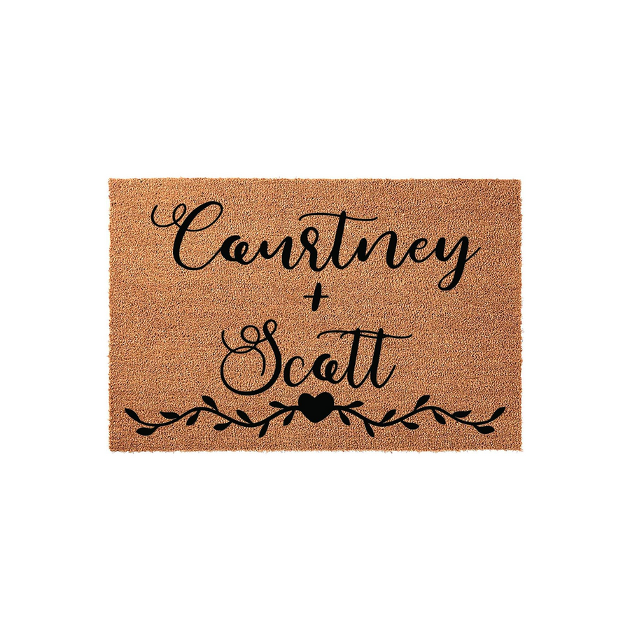 Personalized couple doormat featuring a natural coir texture with black script lettering and a decorative vine and heart design, providing a welcoming entrance for a home while showcasing a custom name design on a durable outdoor