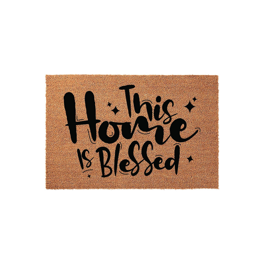 This Home Is Blessed coir doormat features a natural brown fiber texture with bold black script lettering that reads This Home Is Blessed, creating a welcoming and rustic entryway decor piece for your front porch or house