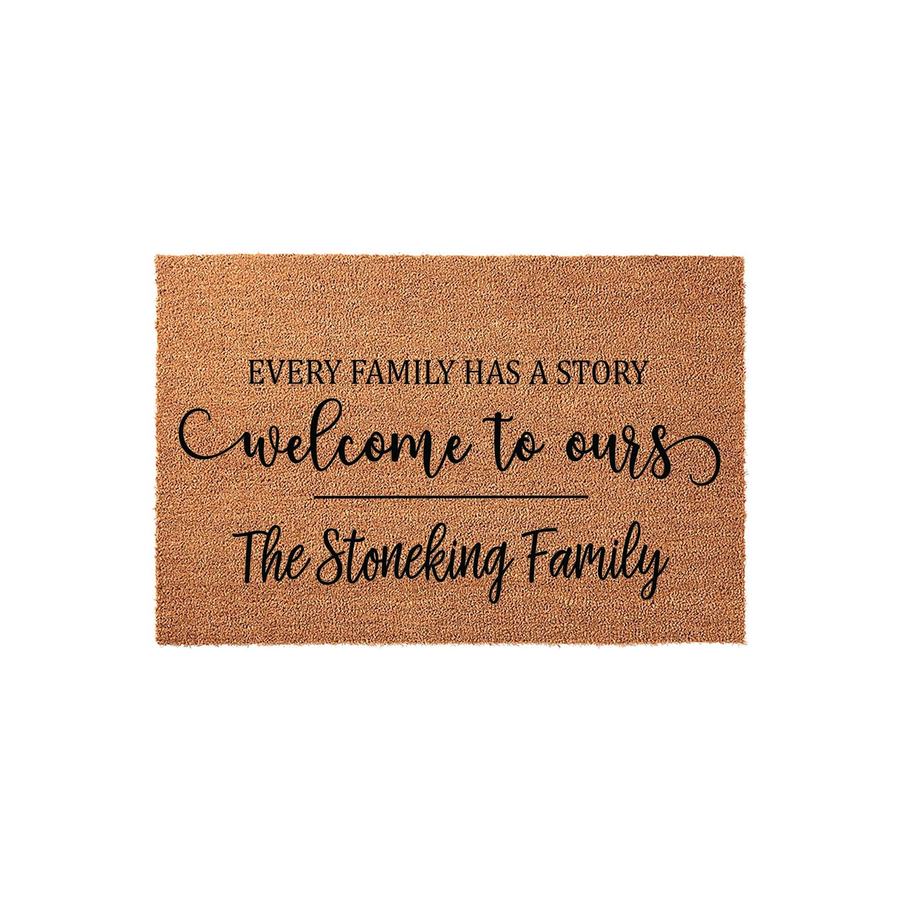 Personalized family name coir doormat featuring the text Every family has a story, welcome to ours, and a custom last name printed in black ink on a natural brown textured fiber background for a rustic front porch entryway decor.