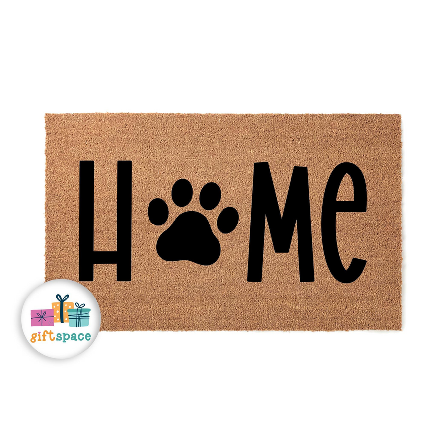 Paw Print Home Coir Doormat featuring a natural tan fiber texture with bold black lettering that replaces the letter O with a large dog paw print, creating a welcoming entryway decor piece for any pet lover's front porch or home
