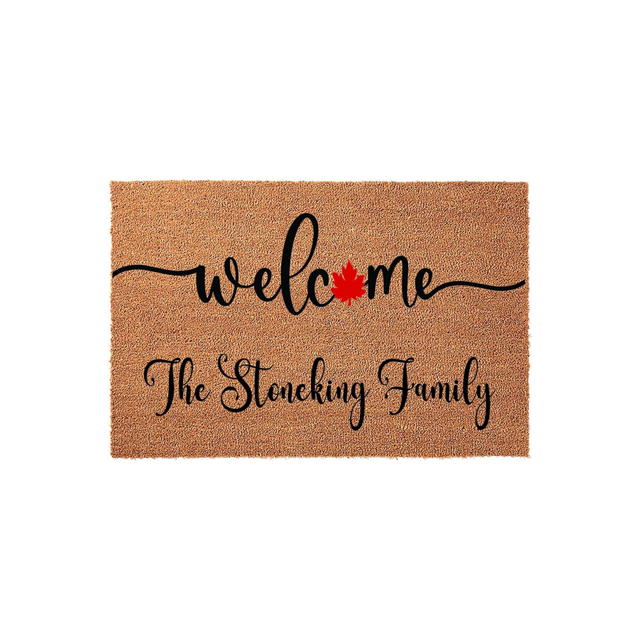Personalized Maple Leaf Welcome Doormat featuring a natural coir texture with black cursive text that says welcome with a red maple leaf accent and a custom family name printed below on a clean white background for a front porch