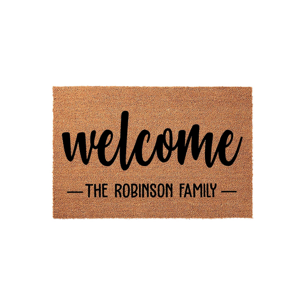 Personalized coir welcome doormat featuring a natural tan fiber texture with bold black script lettering that says welcome and includes a customizable family name line, creating a classic entryway decor piece for any home front