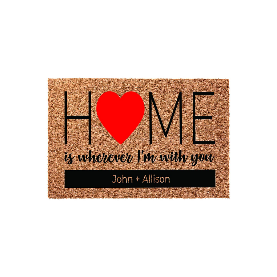 Personalized Home Is Wherever I Am With You Coir Doormat featuring a large red heart replacing the letter O in the word Home, set against a natural brown fiber background with a custom name bar at the bottom for a couple's
