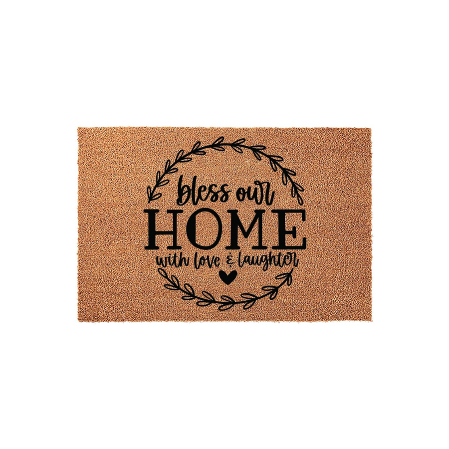 Bless Our Home Coir Doormat featuring a rustic wreath design with the phrase bless our home with love and laughter printed in black ink on a natural tan fiber mat, creating a welcoming entryway decor piece for any front porch.