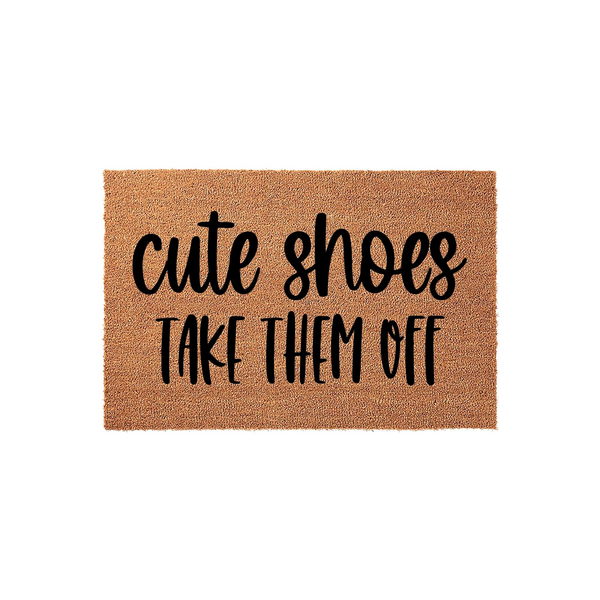 Cute Shoes Take Them Off funny doormat featuring bold black typography on a natural tan coir fiber background, designed to keep your entryway clean while adding a playful touch to your home decor for guests arriving at your front