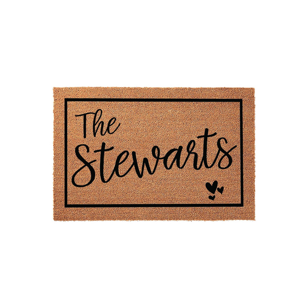 Personalized family name coir doormat featuring a black rectangular border, elegant script lettering for the family name, and three small decorative hearts in the corner, set against a clean white studio background for a modern