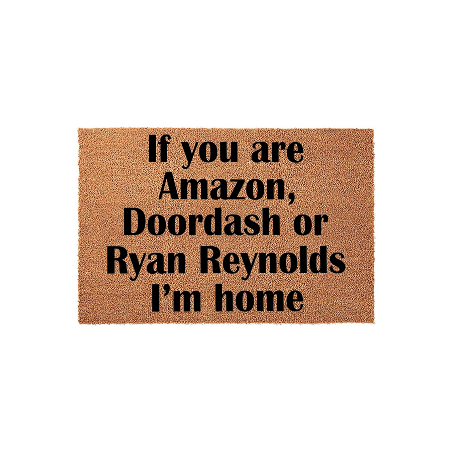 Funny Welcome Doormat featuring bold black text on a natural coir fiber background that reads If you are Amazon, Doordash or Ryan Reynolds I am home, making it a humorous front porch decor piece for any home entrance or apartment