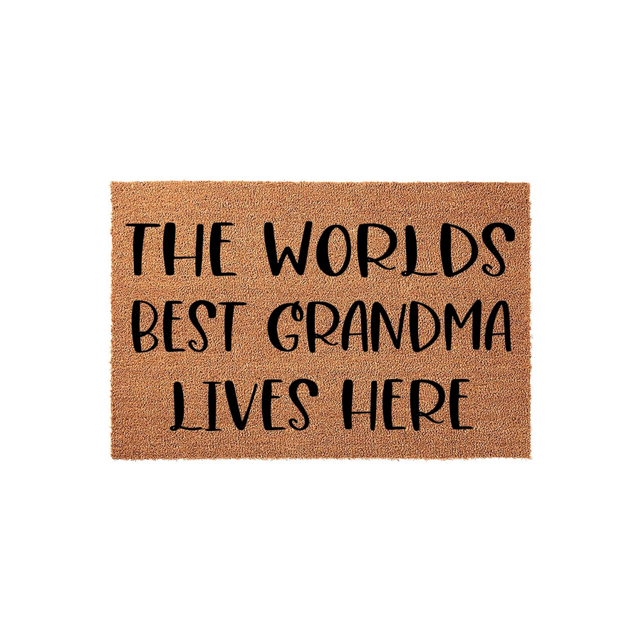 Worlds Best Grandma Lives Here coir doormat featuring bold black text printed on a natural brown coconut fiber mat, providing a welcoming and durable entryway floor covering for a grandmother's home on a clean white background.