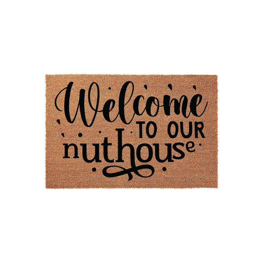 Welcome to our nuthouse coir doormat featuring bold black typography printed on a natural brown fiber background, creating a humorous and inviting entryway accent for your front porch or home entrance on a clean white studio