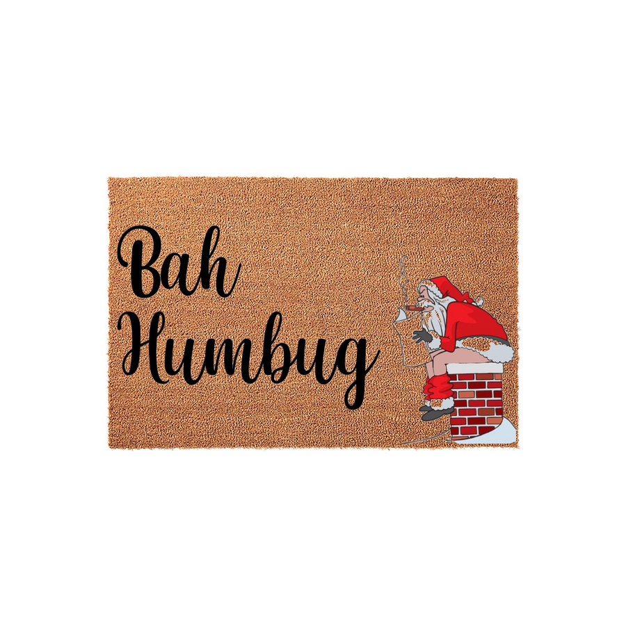 Bah Humbug Christmas doormat featuring a funny illustration of Santa Claus sitting on a brick chimney while smoking a cigar, set against a natural tan coir background for a humorous holiday entryway decor piece for your front