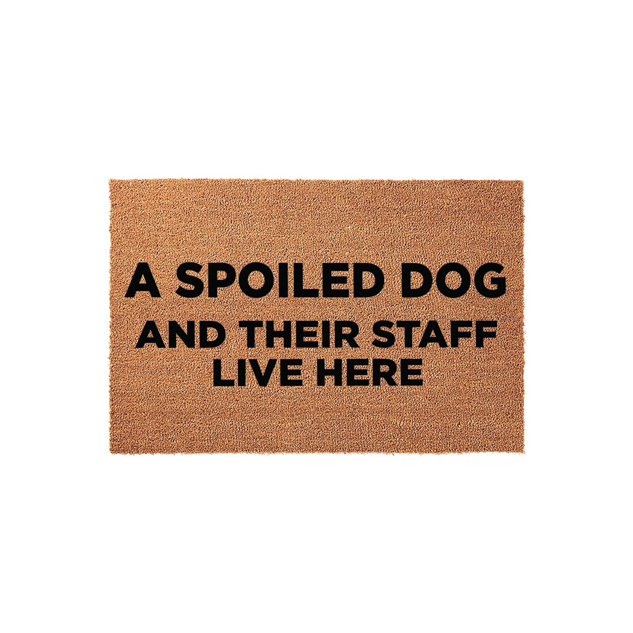 Spoiled Dog Welcome Doormat featuring a natural coir texture with bold black text that reads A SPOILED DOG AND THEIR STAFF LIVE HERE, making it a humorous and functional entryway rug for any pet lover's home on a clean white