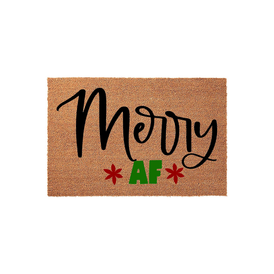 Merry AF Christmas doormat made of natural coir fiber with a rectangular shape, featuring bold black script lettering and green text accented by two red star-like floral icons on a plain white background for a festive holiday