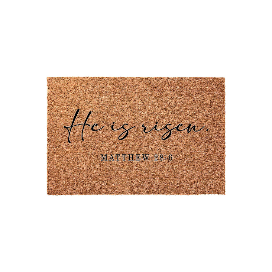 He Is Risen Matthew 28:6 Coir Doormat featuring a natural brown fiber texture with elegant black script and serif lettering, providing a welcoming religious entryway accent for the Easter season on a clean white studio background.