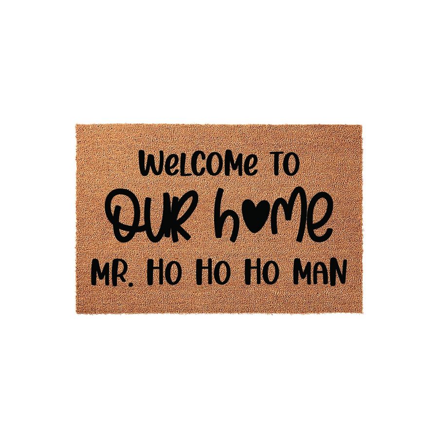 Christmas Welcome To Our Home Mr. Ho Ho Ho Man Doormat featuring natural coir fiber material with bold black lettering and a heart icon, creating a festive holiday entryway decor piece for your front porch or home entrance.